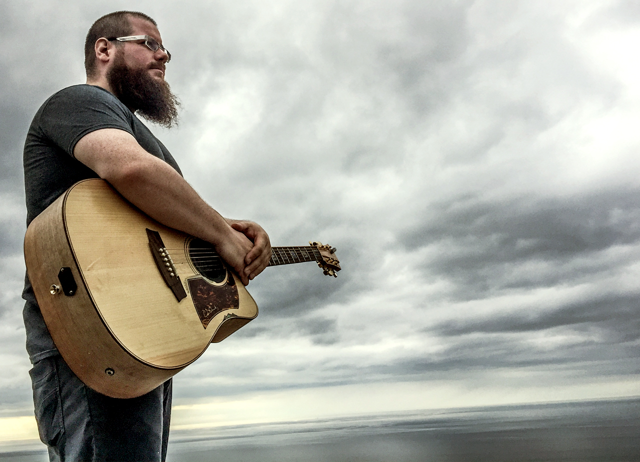 P-A Lemay guitare à la main devant un ciel immense